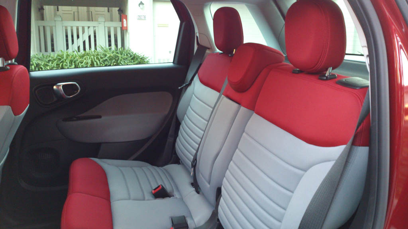 The second row sits higher than the front, providing a “stadium effect.” Two would be comfortable in the sliding AND reclining second row. Legroom is above average. Headroom destroys anything short of a bus. The D-pillar window is branded “Freeglass,” which is like Plexiglas, on which window tint will not stick. Most 500L trims come with decent factory tint. Fold-down armrest has just one pop-out cupholder.